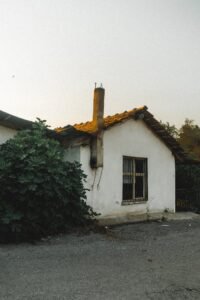 Small House with a Mossy Roof and Bars on the Window